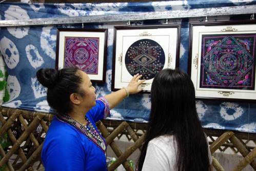 梁小哲在作坊向回访小组展示和讲解自己的作品